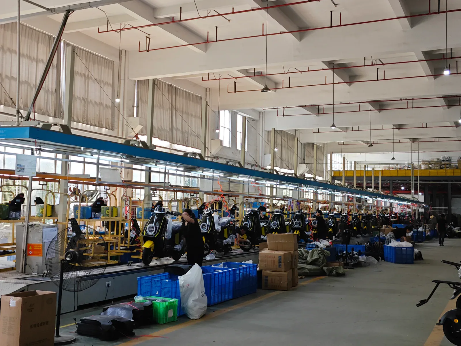 Electric two-wheelers on an assembly line inside the company facilities